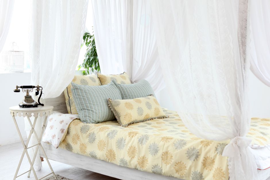 Zomerslaapkamer met witte linnen gordijnen.