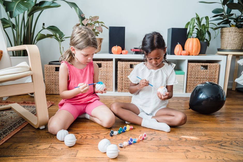 Kinderen maken pompoenlantaarns met vrolijke gezichten.